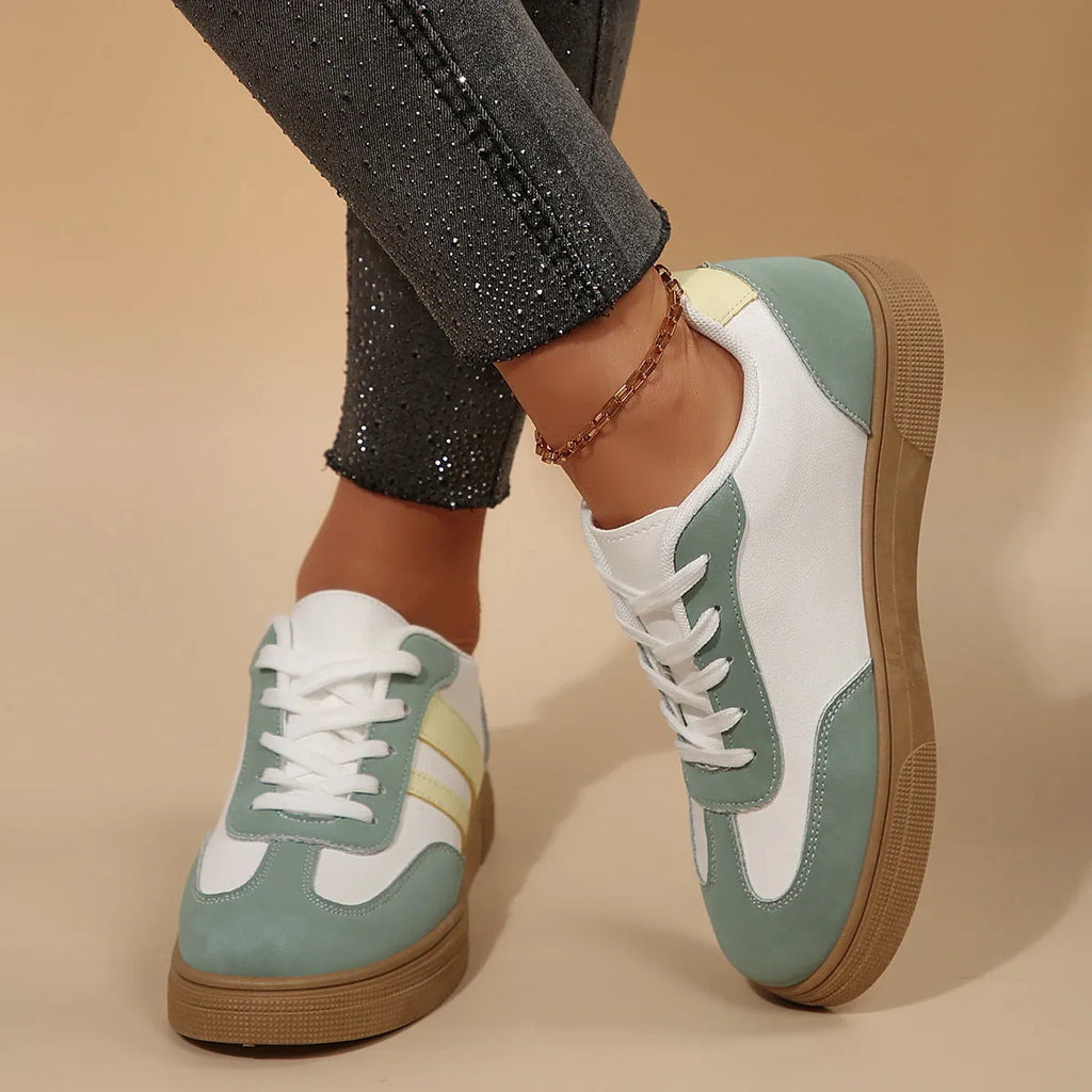 Green women's low-top retro sneakers with white cross straps and stitching on a PU upper.