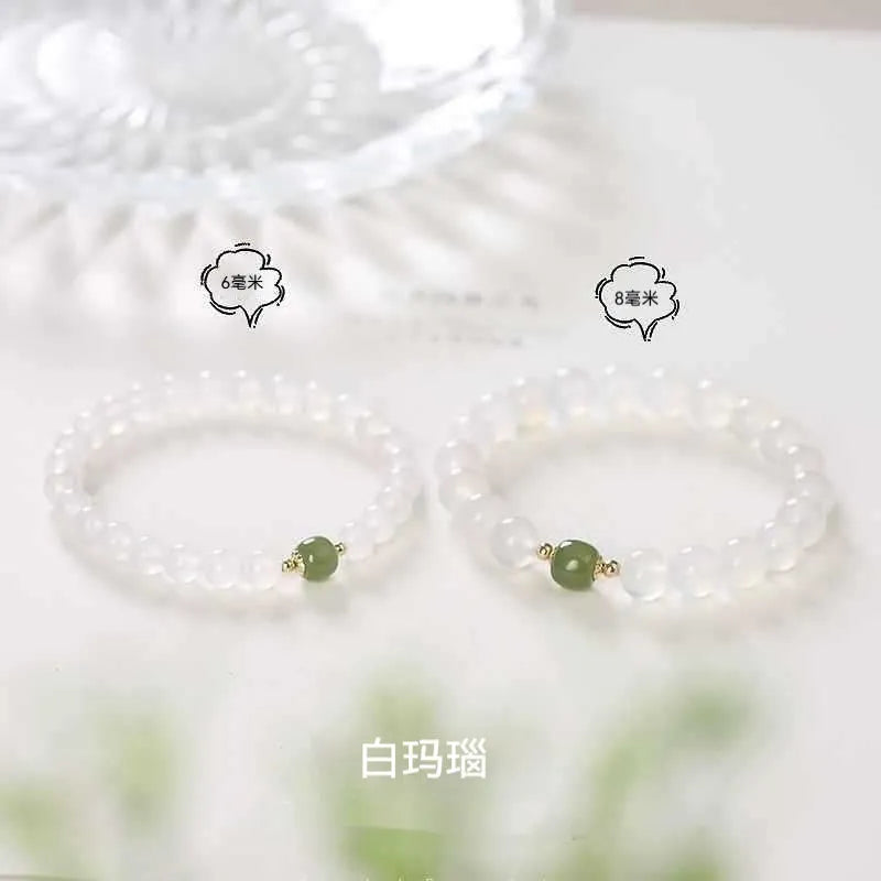 Handmade natural white agate crystal bracelet with cinnabar inlay on wrist, showing 8mm round beads.