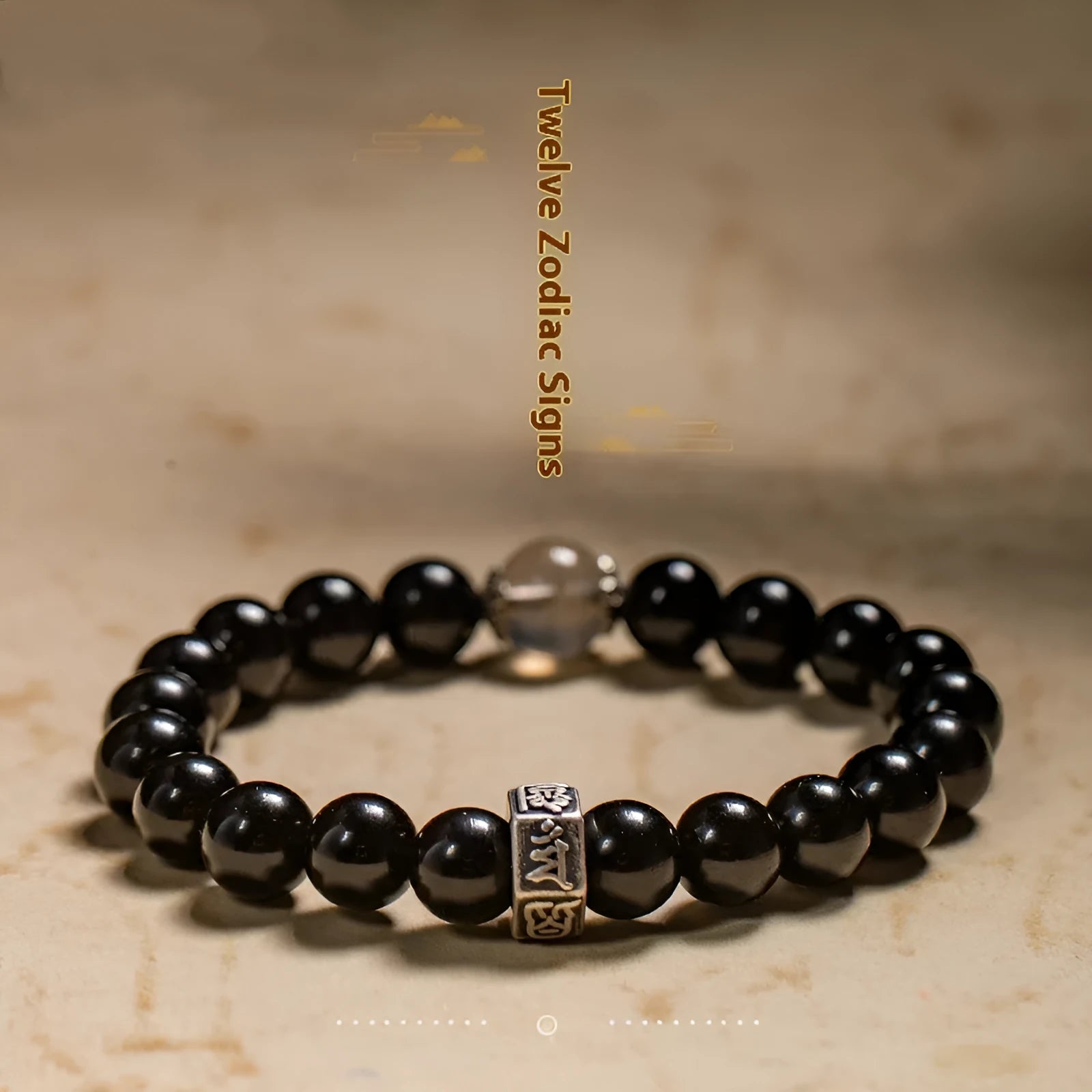Close-up of an 8mm obsidian beaded bracelet with zodiac and Buddhist bodhisattva designs.