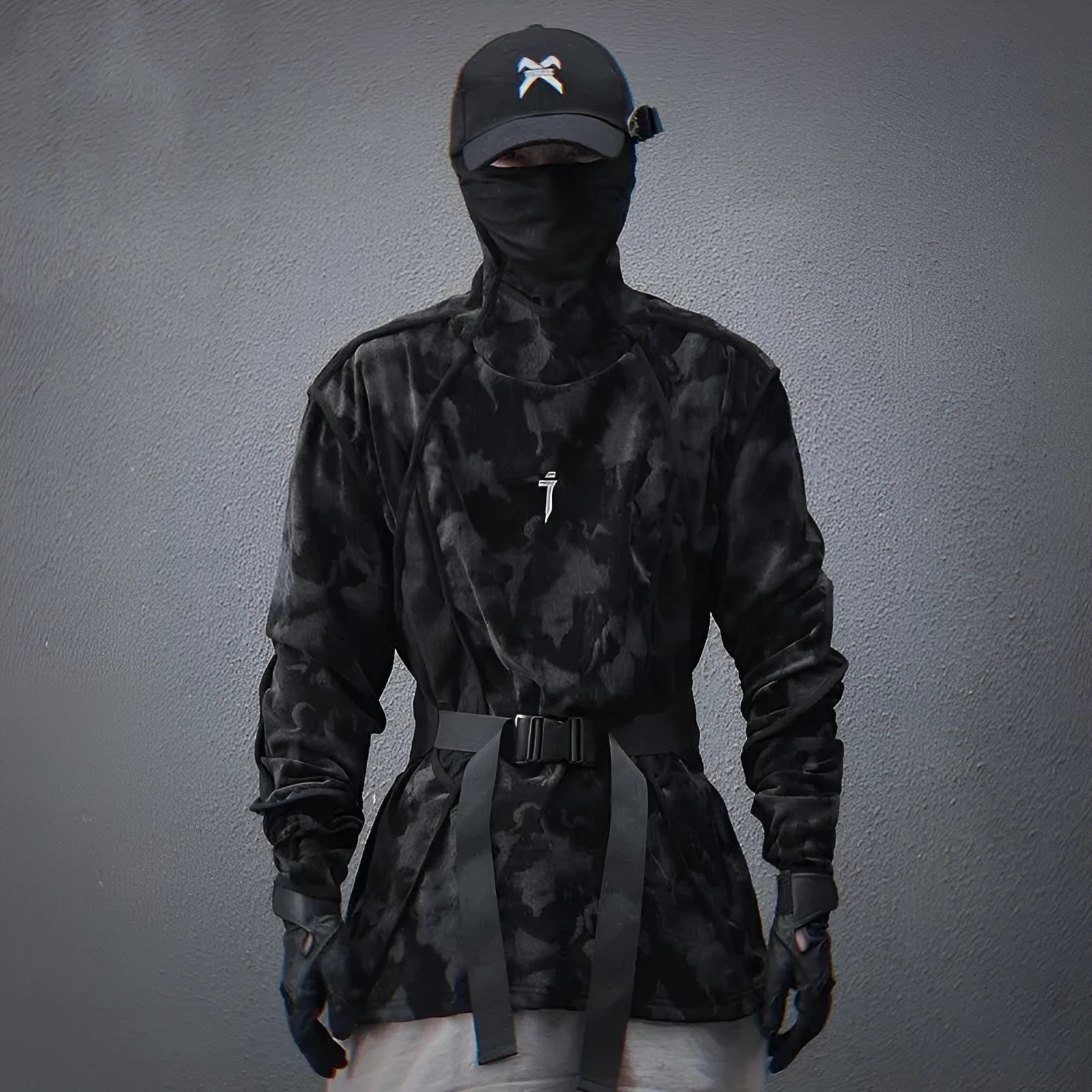 Men's black tie dye patterned pullover sweater with turtleneck and drop shoulders on a grey background.