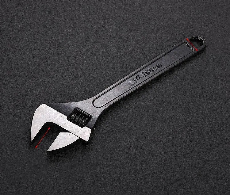 High carbon steel adjustable open-end spanner with black finish on a workbench.