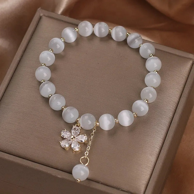White cat's eye crystal bracelet with flower tassel and safety buckle for women.