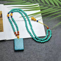 Turquoise lucky pendant necklace with hand-woven mesh flower design on adjustable ball bead chain
