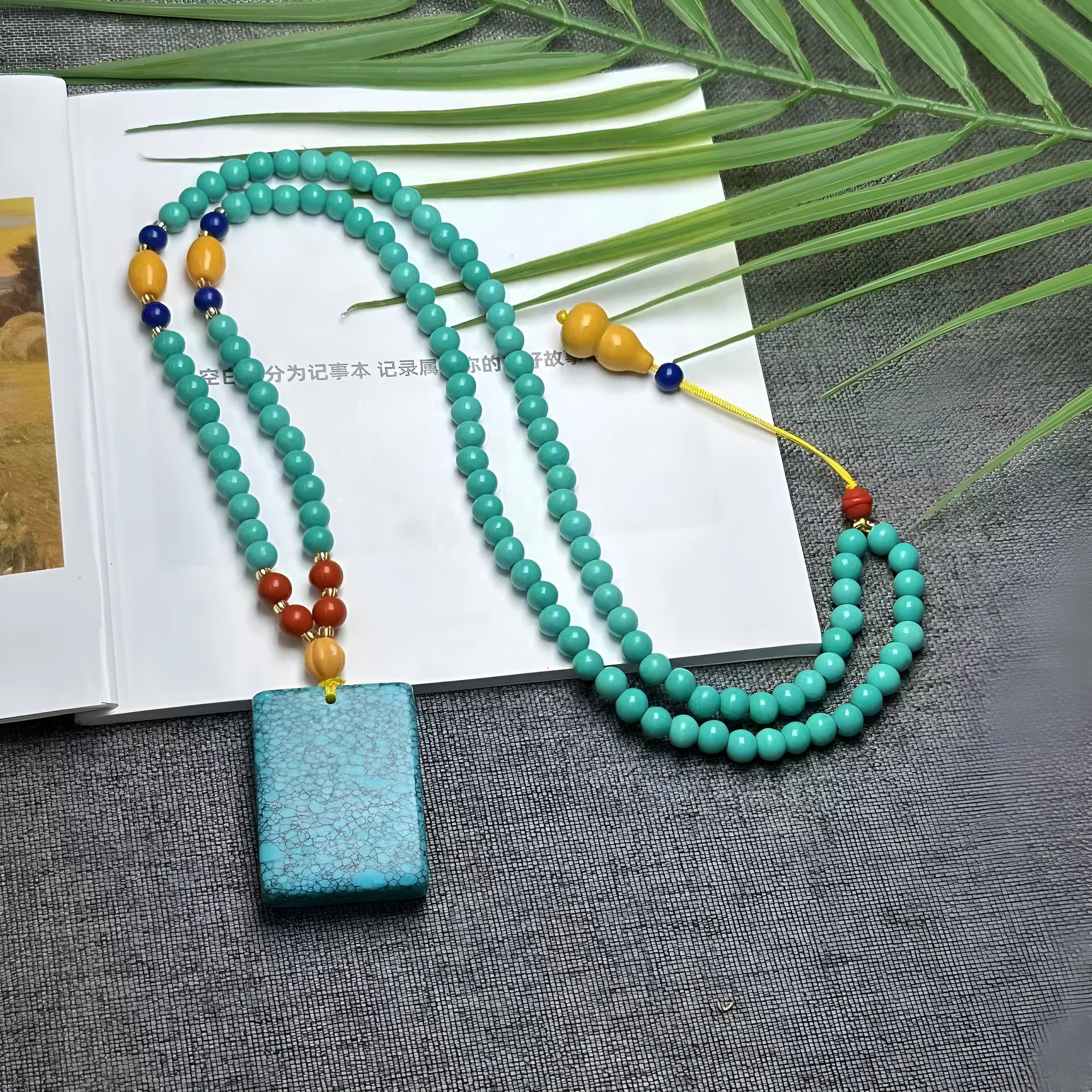 Turquoise lucky pendant necklace with hand-woven mesh flower design on adjustable ball bead chain