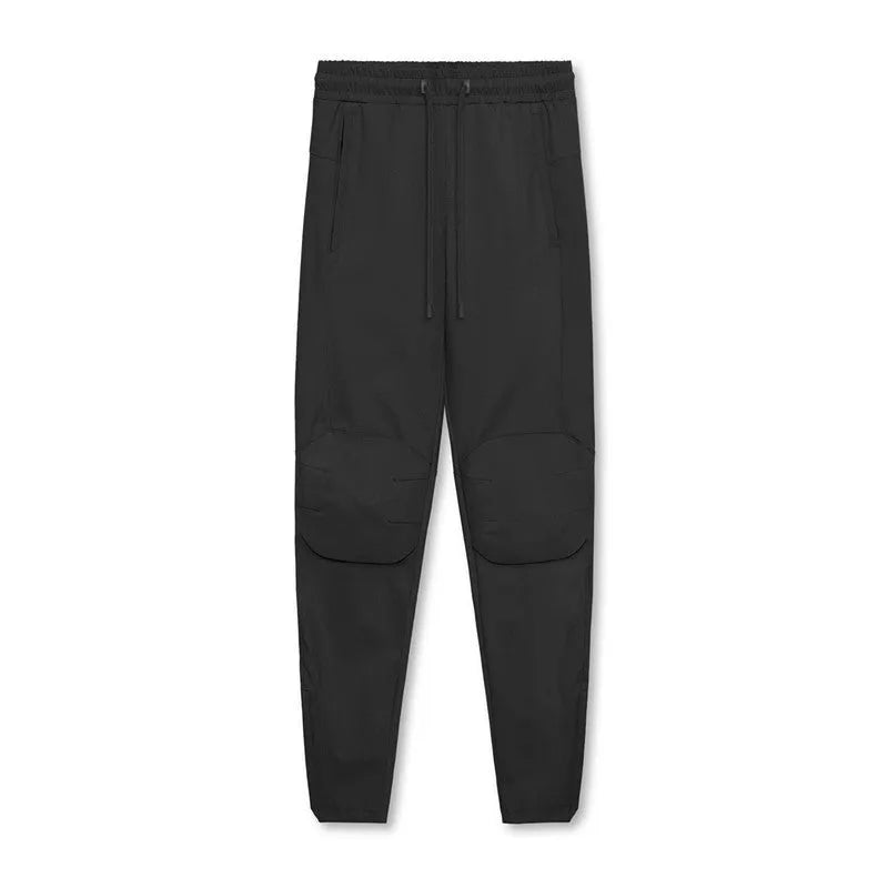 Man wearing dark grey loose-fit ankle-tied running pants made from quick-drying polyester fabric.