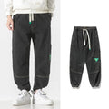 Men's loose-fit tapered trousers in black, available in sizes M through 8XL