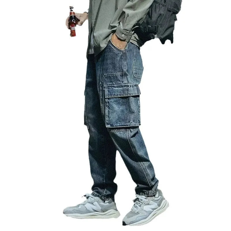 Man wearing blue loose straight-leg denim trousers with a zip fly, showcasing a casual retro style.