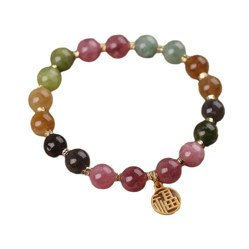 Tourmaline bracelet with floral or fu character design on a white background.