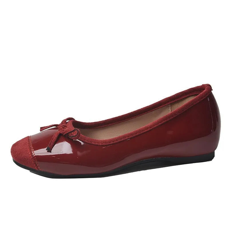Wine red Mary Jane ballet flats with a bow and square toe on a rubber sole.
