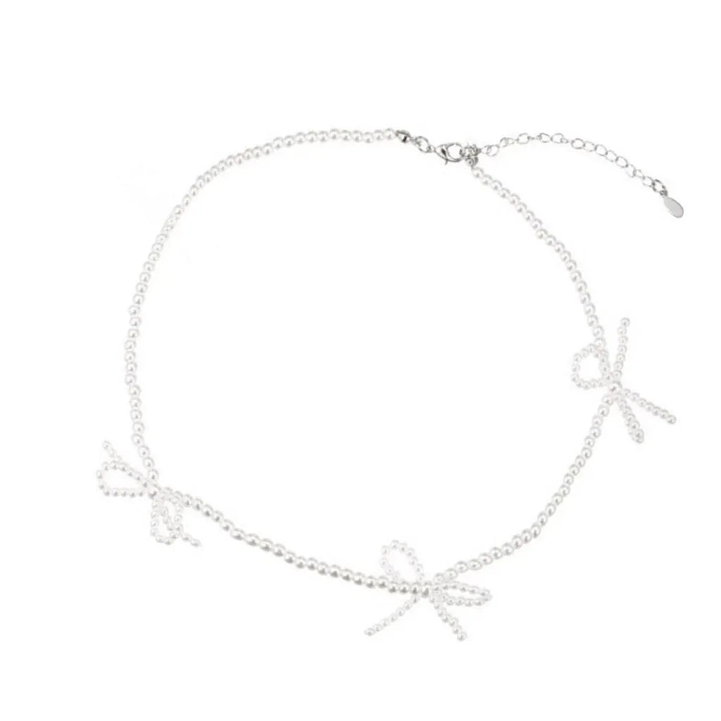 Women's white bow-shaped imitation pearl necklace with an adjustable chain.