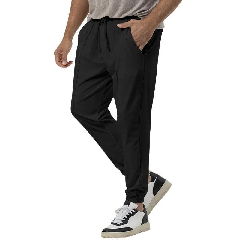 Men's grey straight-leg casual track sweatpants made from cotton blend fabric on a neutral background.
