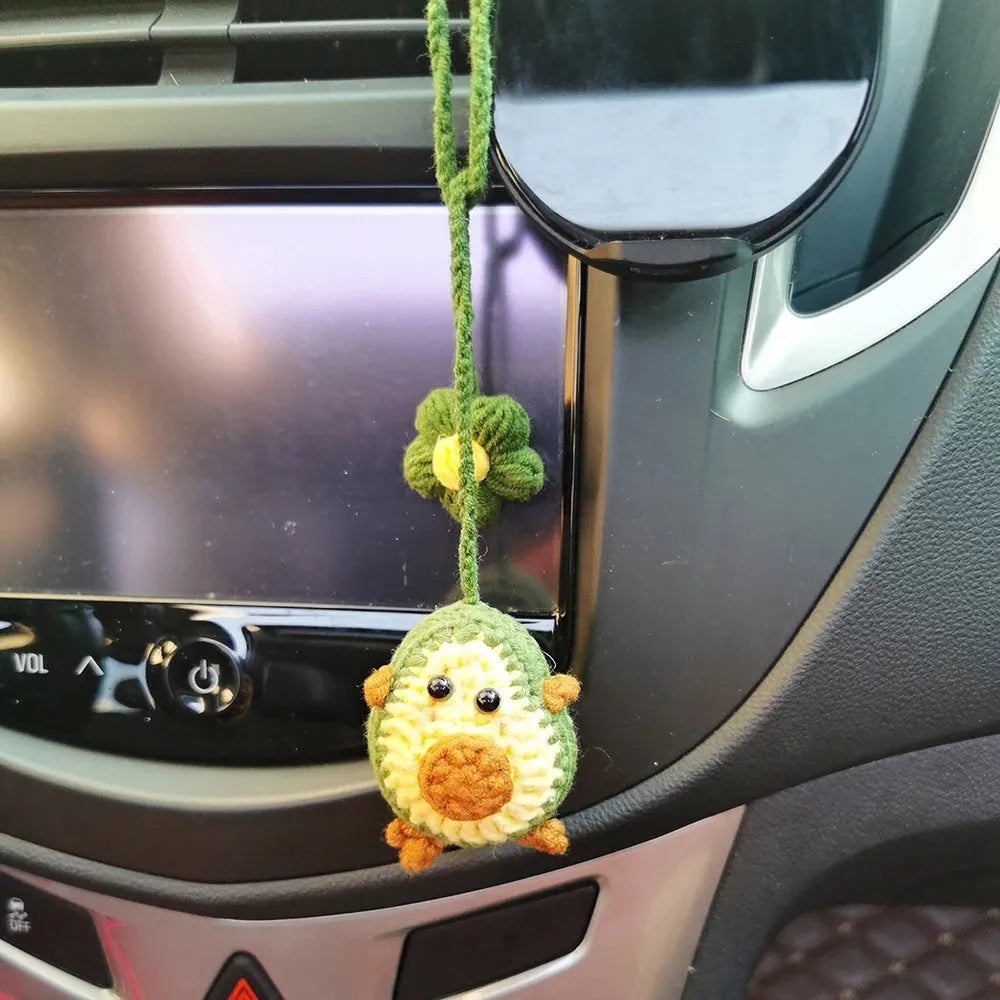 Handmade crocheted car pendant in avocado, pink rainbow, and red rainbow cartoon designs.