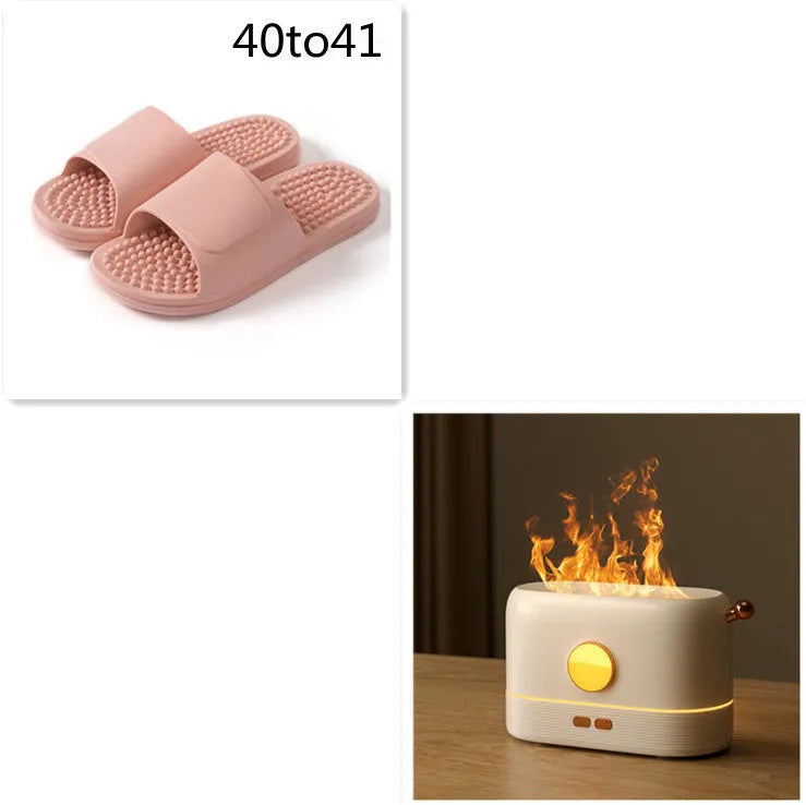 Black USB desktop humidifier with LED flame effect and water tank on a wooden desk.