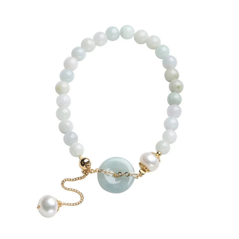 Green jade peace buckle charm and pearl beaded bracelet for women on a white background.