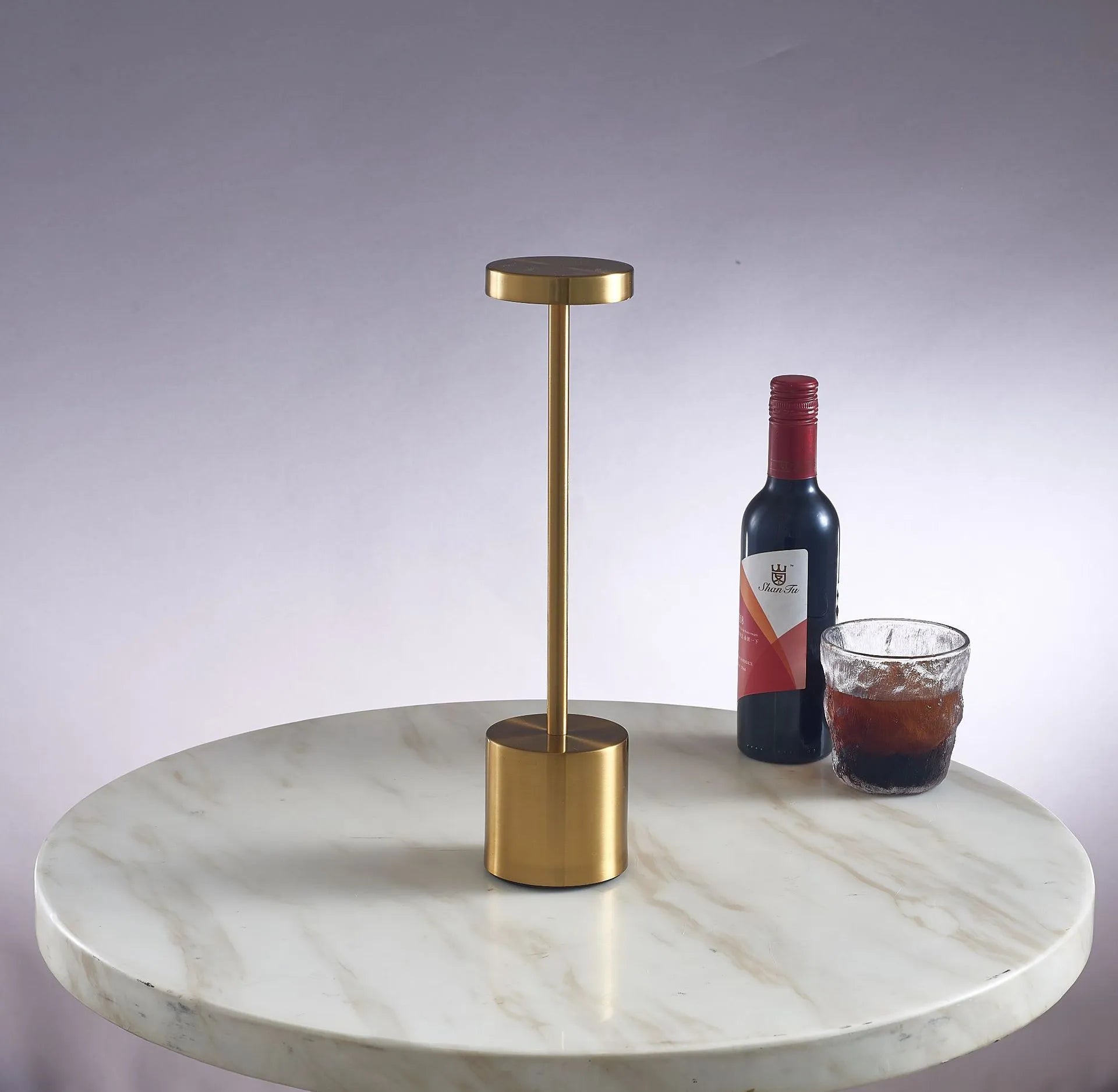 Metal touch desk lamp in gold finish with LED light on, showing compact 34x8cm size