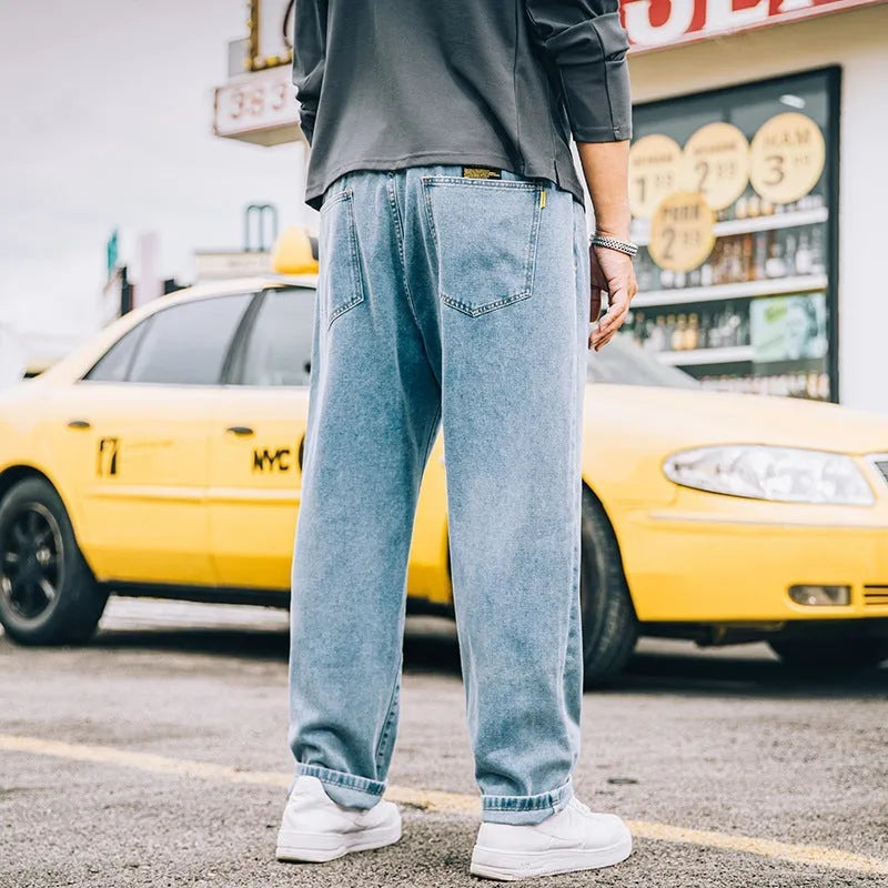Men's loose straight-leg casual jeans in dark blue cotton on a hanger.