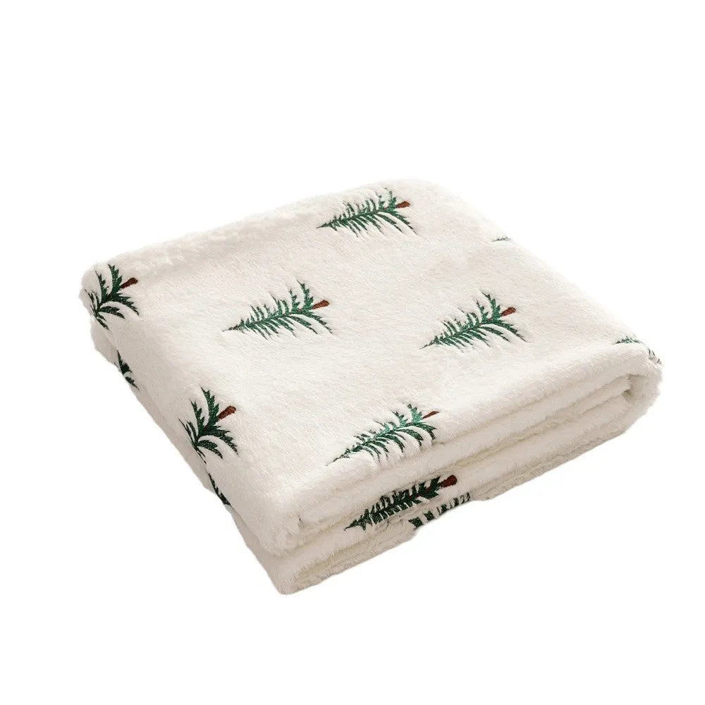 White polyester Christmas plush sofa blanket with embroidered Christmas tree on a sofa