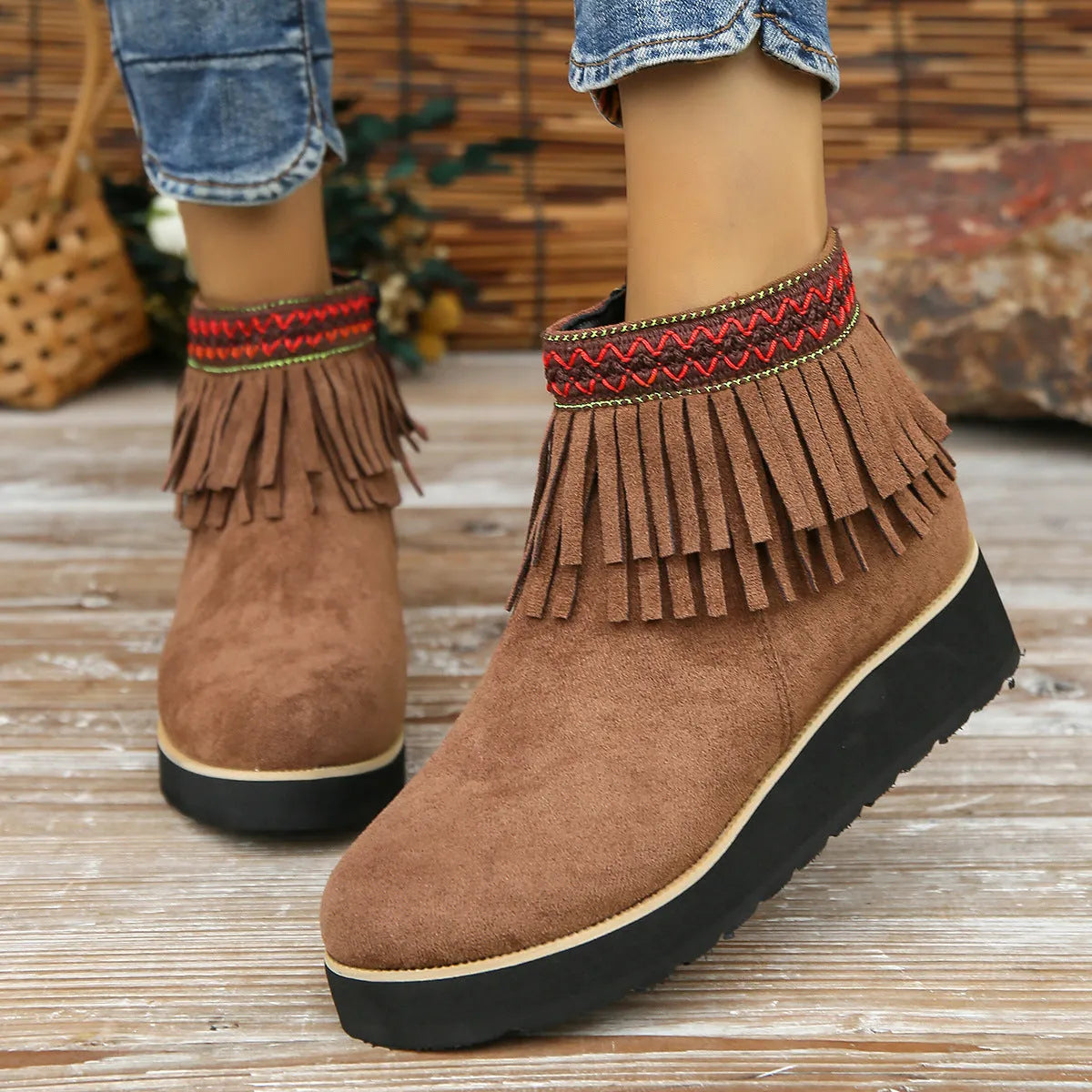 Women's black suede ankle boot with wedge heel, platform sole, side zip, and tassel detail.