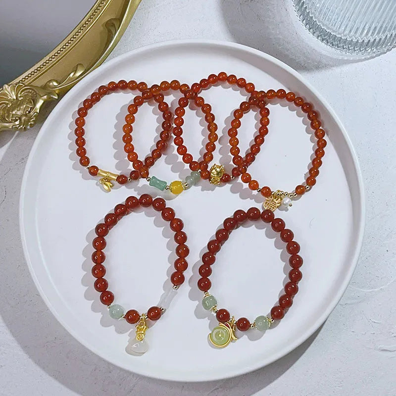 Handmade red agate women's bracelet with dragon design on a wrist.