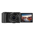 Optical digital micro single camera in black with ultra wide angle lens, touch screen, 117x84x66mm, sling attached, on travel background