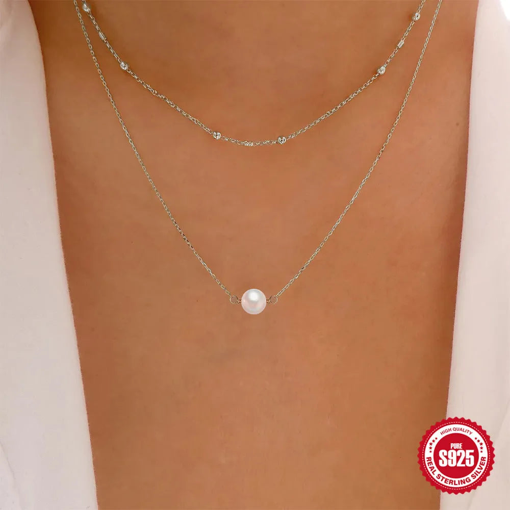 S925 sterling silver double layer necklace with twin diamond-treated pearls and geometric design.