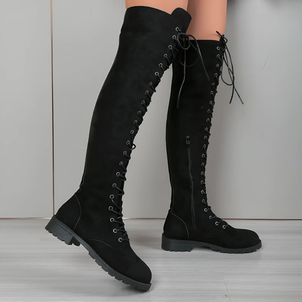 Black lace-up over-the-knee boots with round toe, flat rubber sole, and decorative stitching on the shaft.