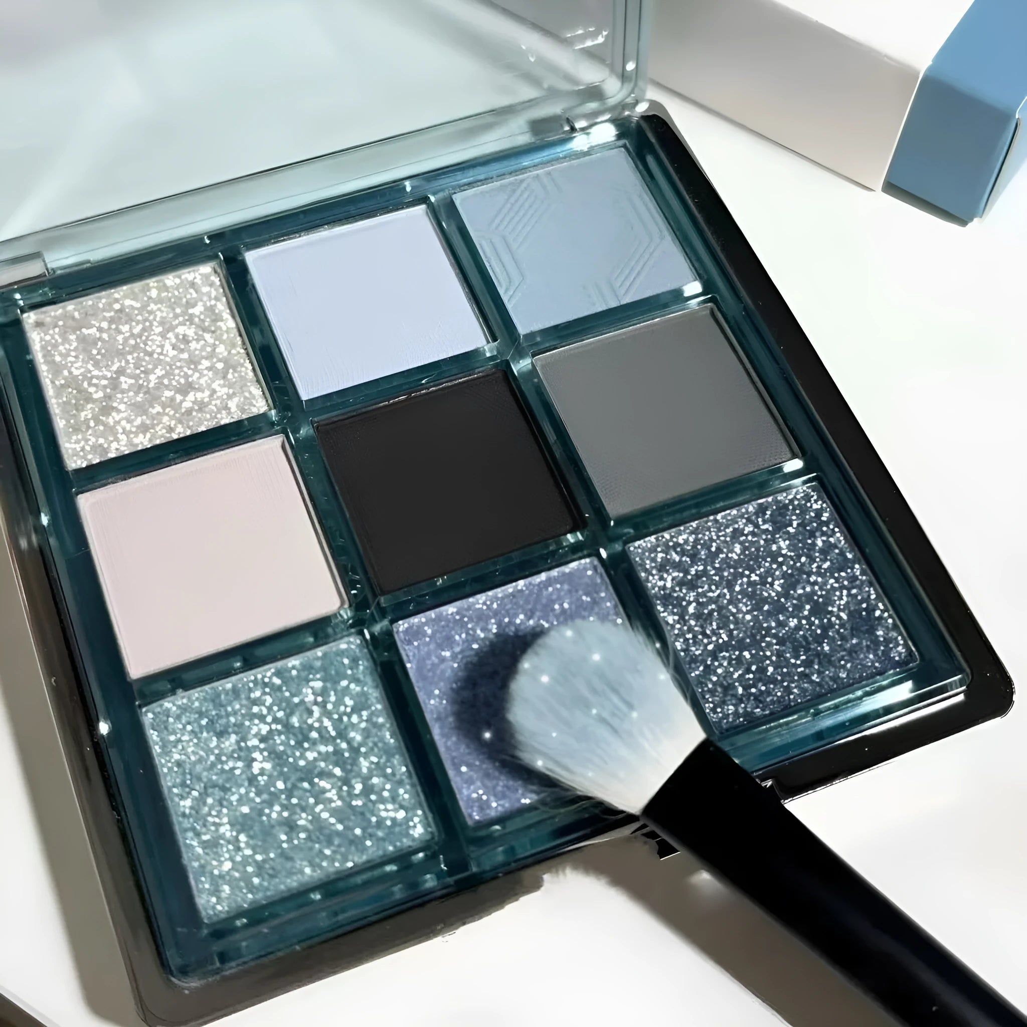 MUGELEEN nine-colour eye shadow palette showing low saturation blue smoked shades with matte and shimmer finishes