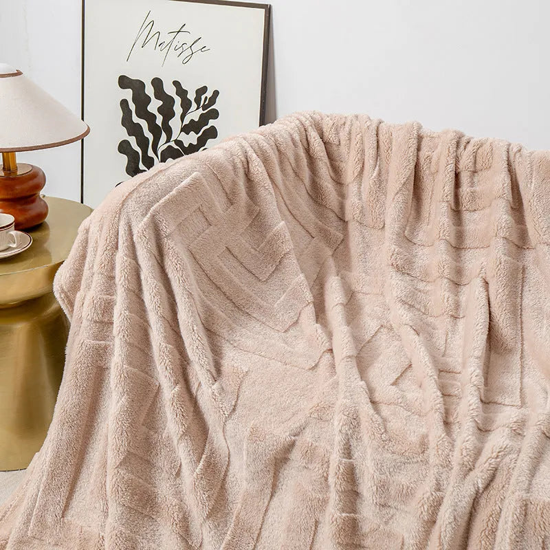 Thick square coral fleece flannel blanket in brown colour shown folded on a sofa