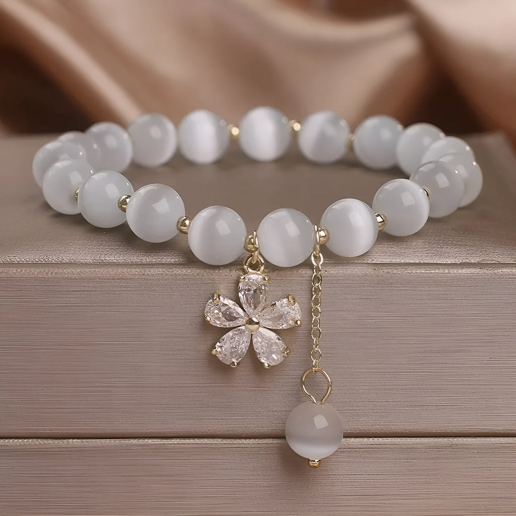White cat's eye crystal bracelet with flower tassel and safety buckle for women.