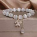White cat's eye crystal bracelet with flower tassel and safety buckle for women.