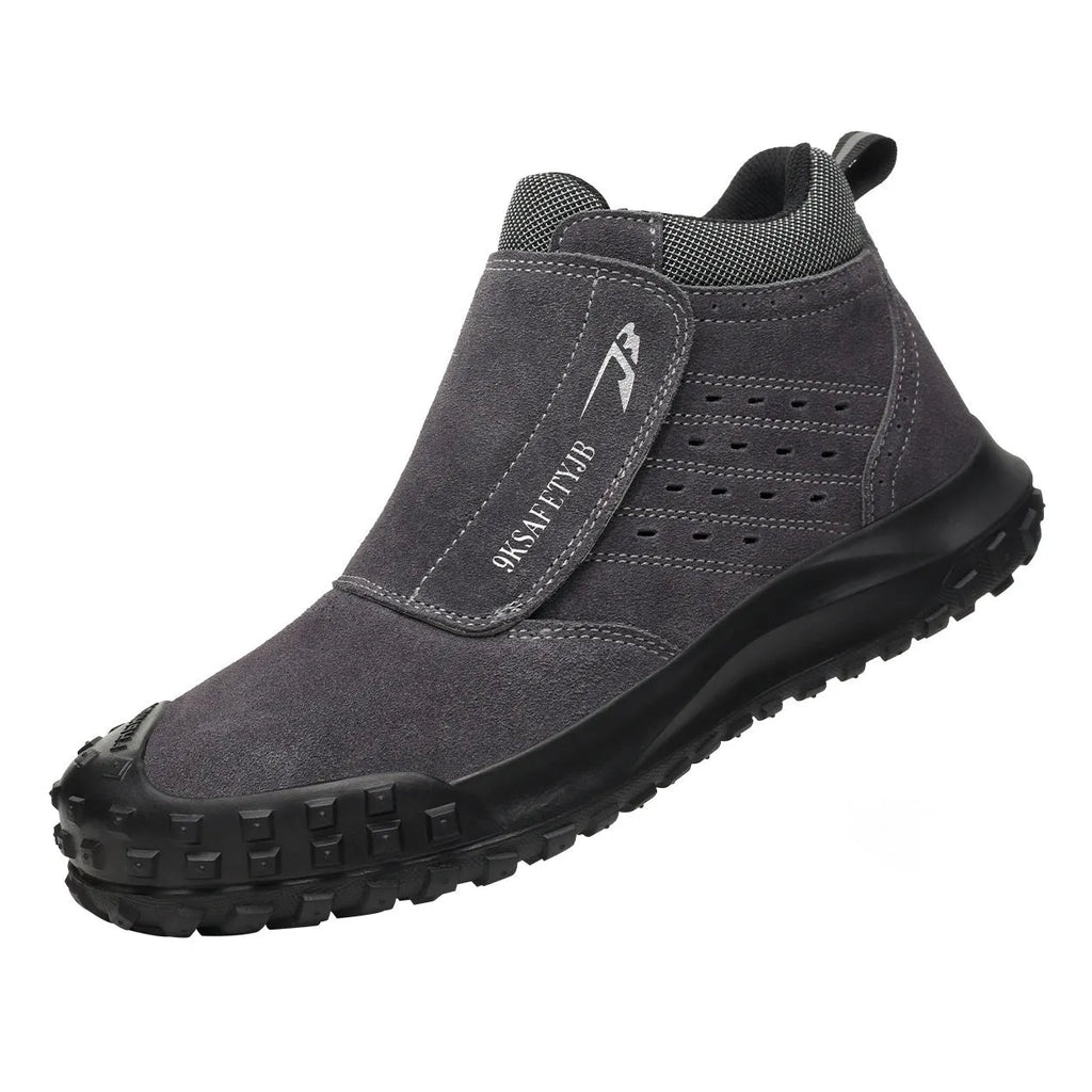 Lightweight grey welder safety shoe with steel toe cap and lace-up front on a worksite background.