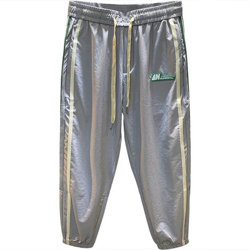 Men's black cotton harem-style casual trousers laid flat, showing relaxed fit and mid-waist design.