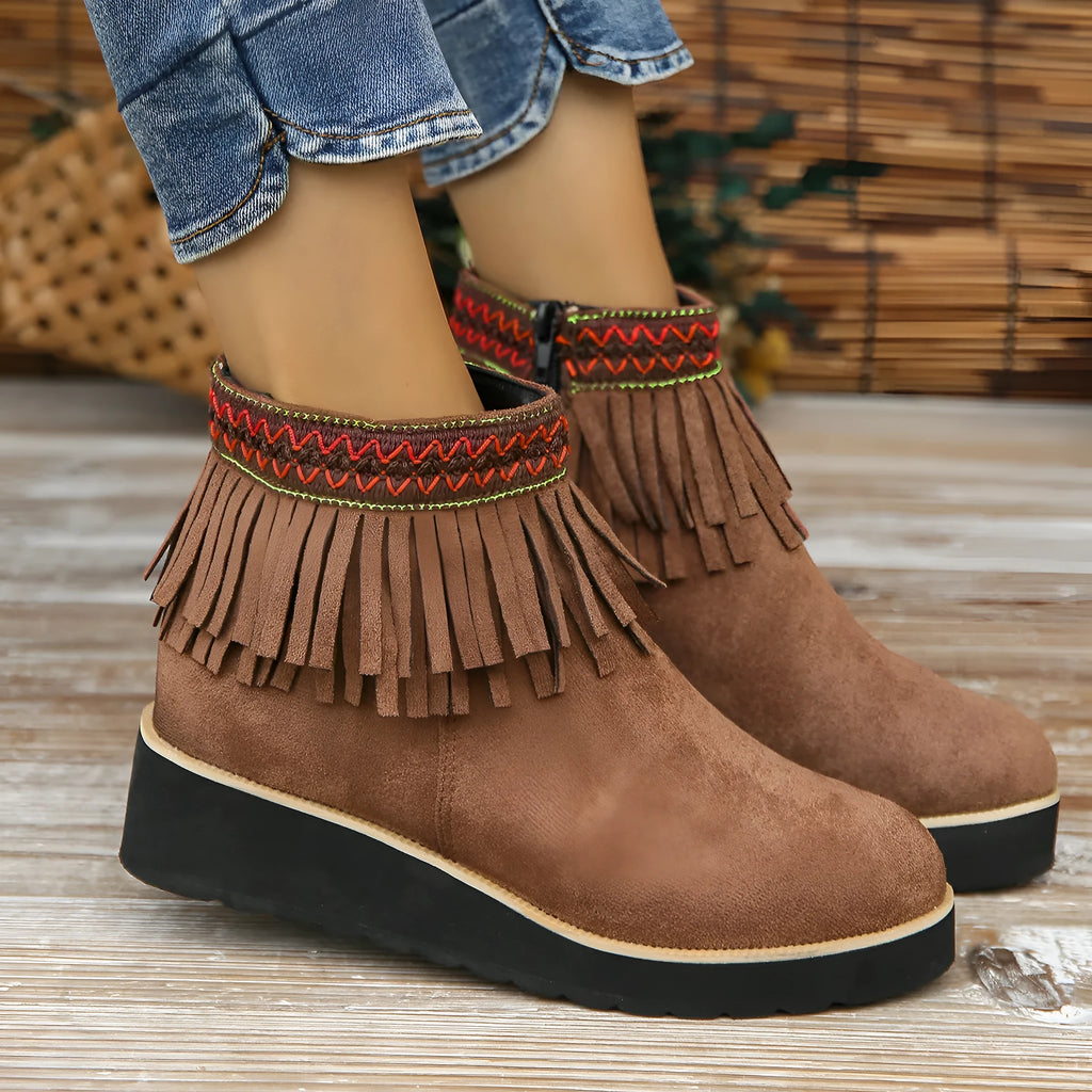 Women's black suede ankle boot with wedge heel, platform sole, side zip, and tassel detail.
