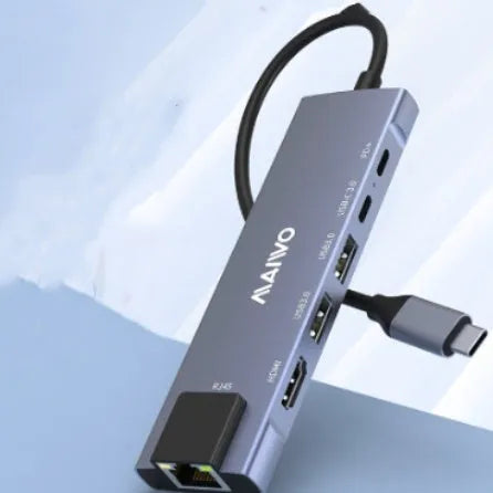 Aluminium Steam Deck six-in-one docking station with HDMI, USB, and Ethernet ports next to a handheld console.