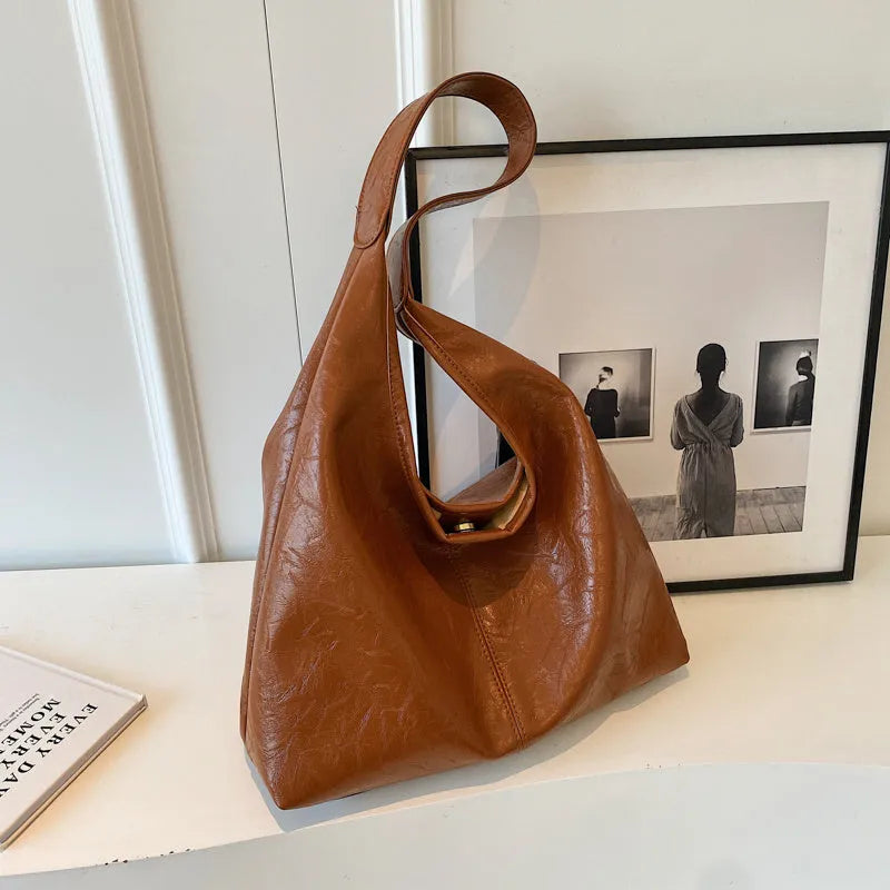 Casual soft PU leather shoulder bag in street trend style with large capacity and sandwich pocket.