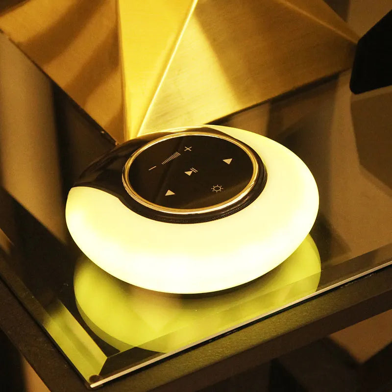 Folding Bluetooth speaker desk lamp with touch controls showing white, yellow, and blue LED lighting options