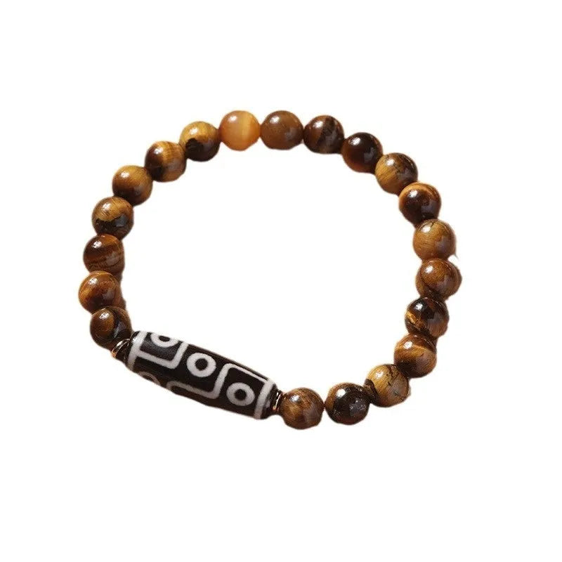 Single circle tigereye Dzi bead Buddhist mala bracelet shown on a wrist.