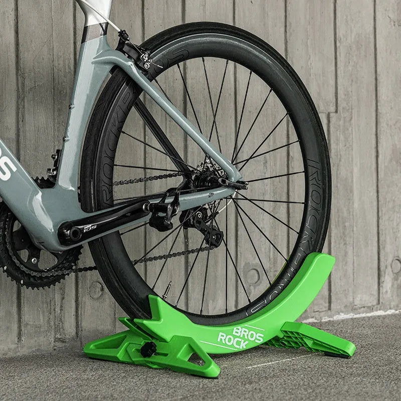 Black and green ABS plastic bicycle parking rack holder with fixed mounting bracket.