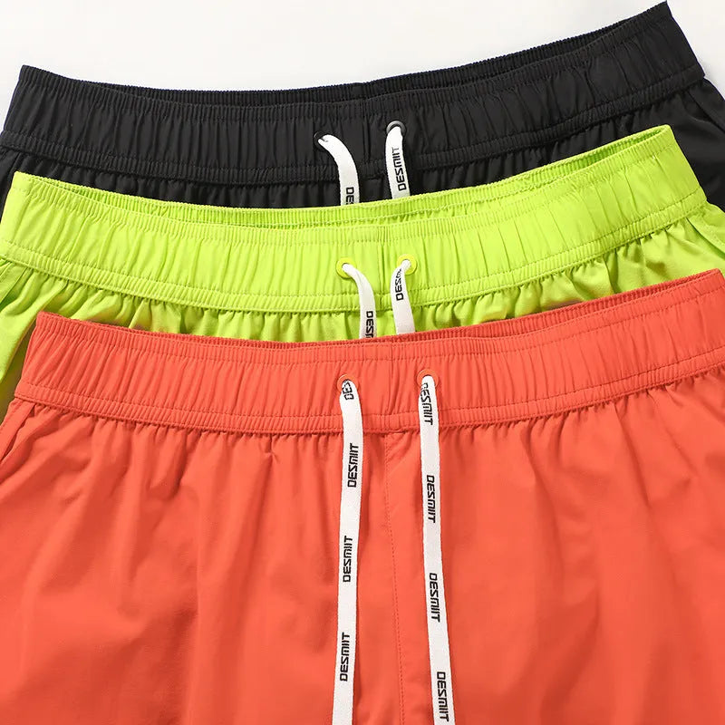 Men's loose polyester beach shorts in black, fluorescent green and orange red colours