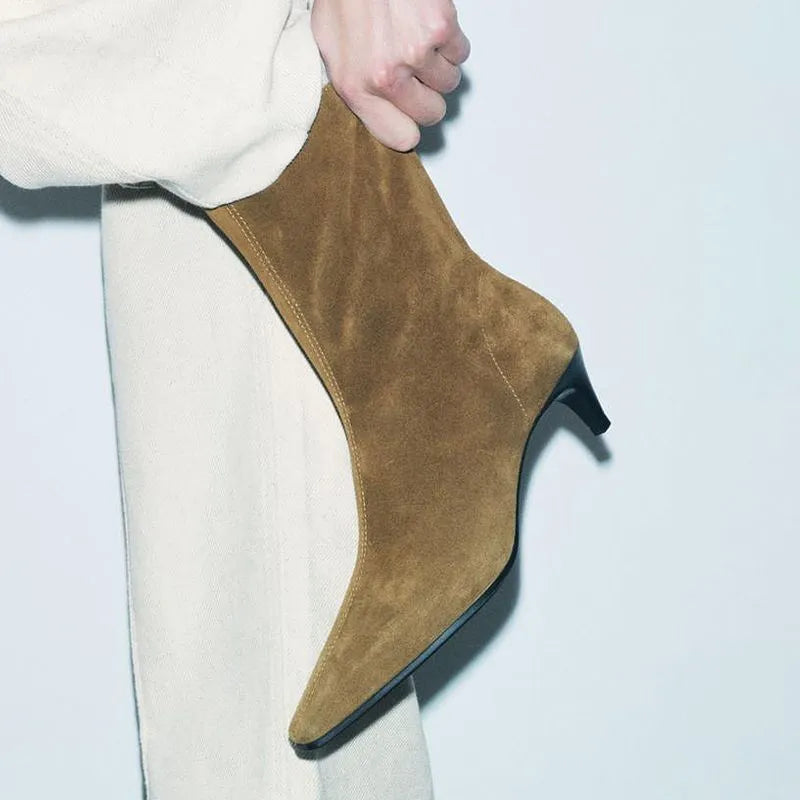 Brown square toe women's boots with a side zipper and a mid stiletto heel on a wooden floor.