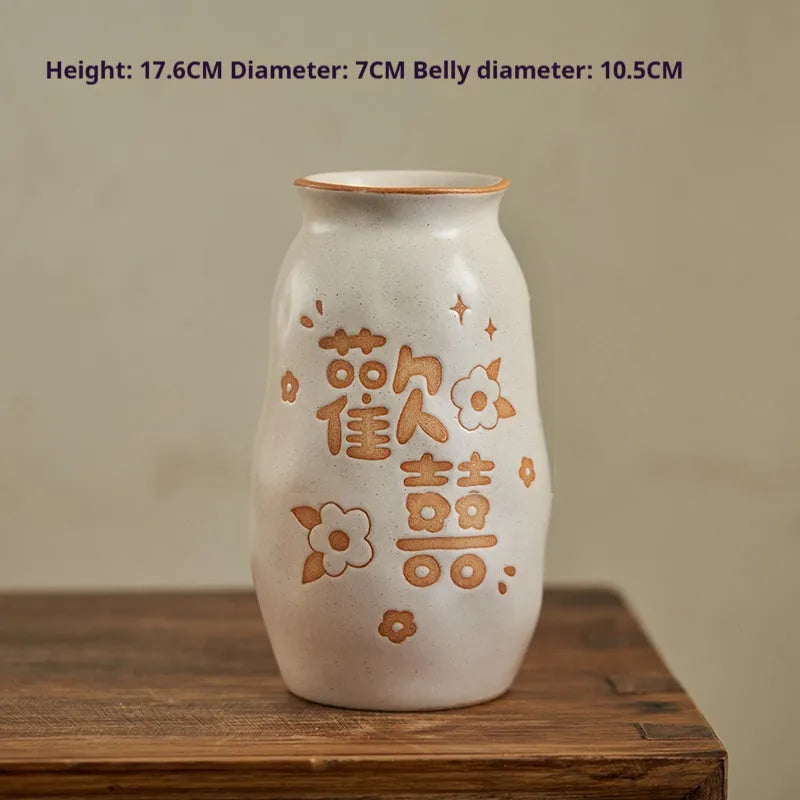 Chinese hand-painted ceramic joy vase with carved decorations on wooden desktop