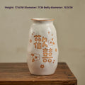 Chinese hand-painted ceramic joy vase with carved decorations on wooden desktop