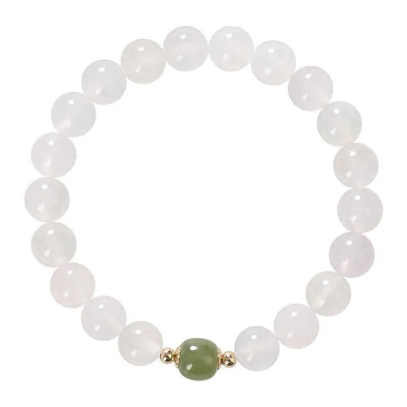 Handmade natural white agate crystal bracelet with cinnabar inlay on wrist, showing 8mm round beads.