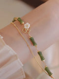 Handmade olivine bracelet with double layer design and twin charms on wrist