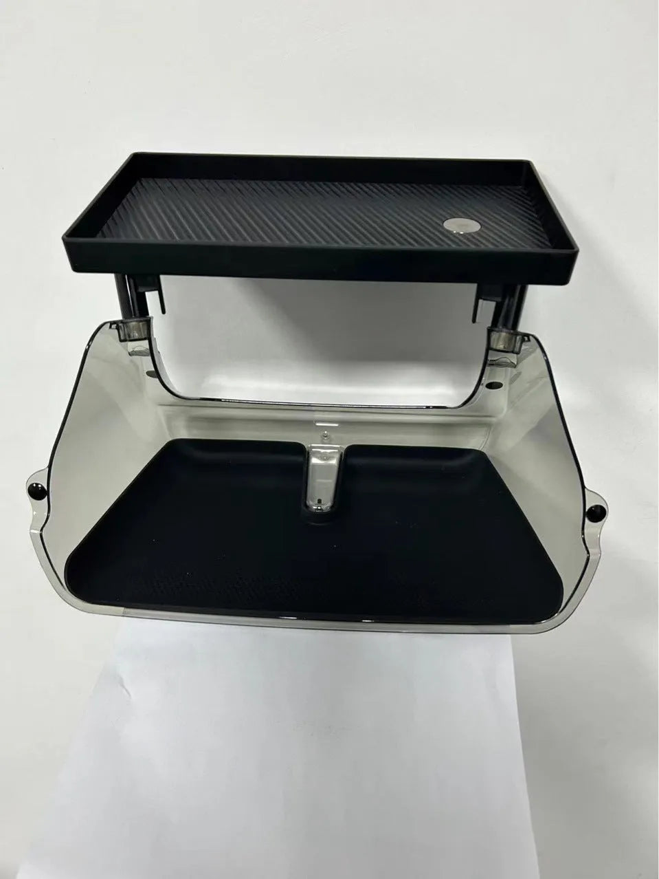 Black ABS plastic storage box installed under the screen of a Tesla Model Y centre console.
