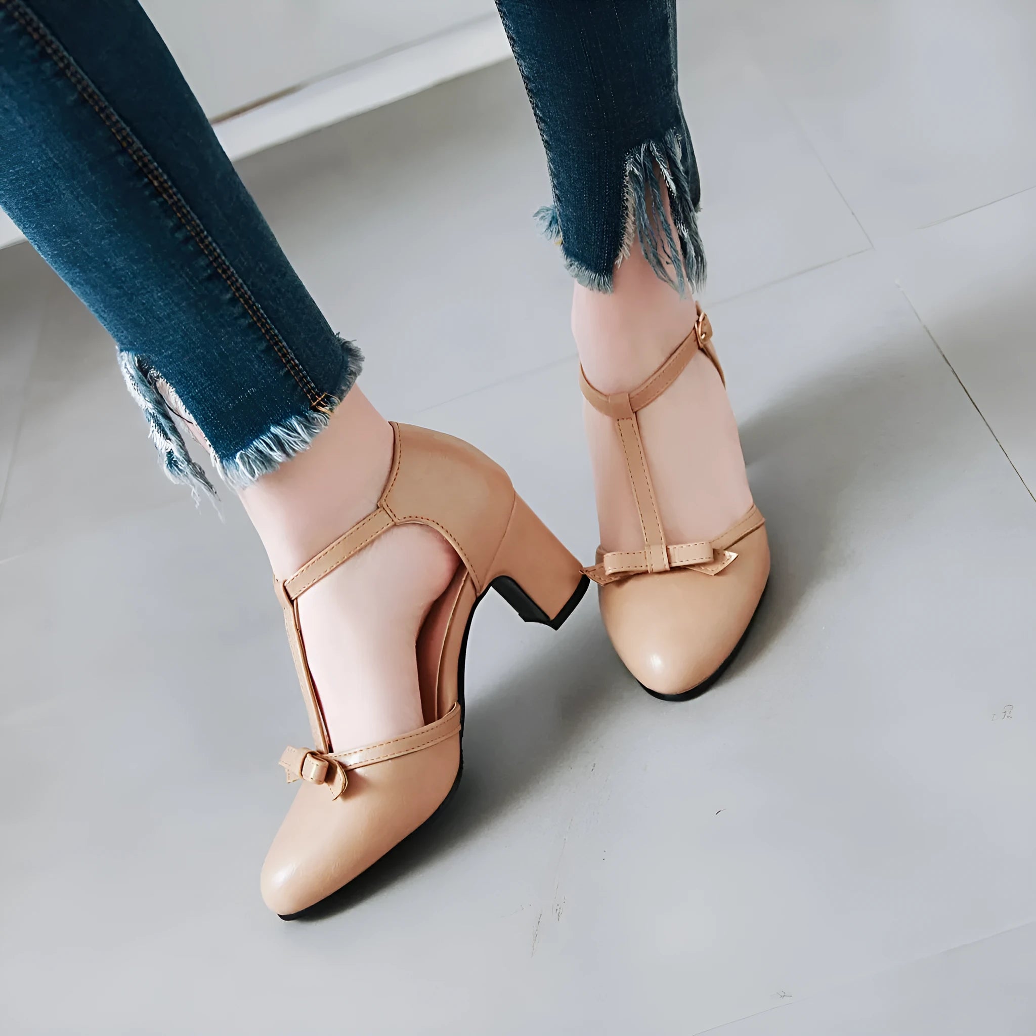 Women's apricot-colour sandals with a chunky heel, bow detail, and a hollow-out buckle strap on a round toe.