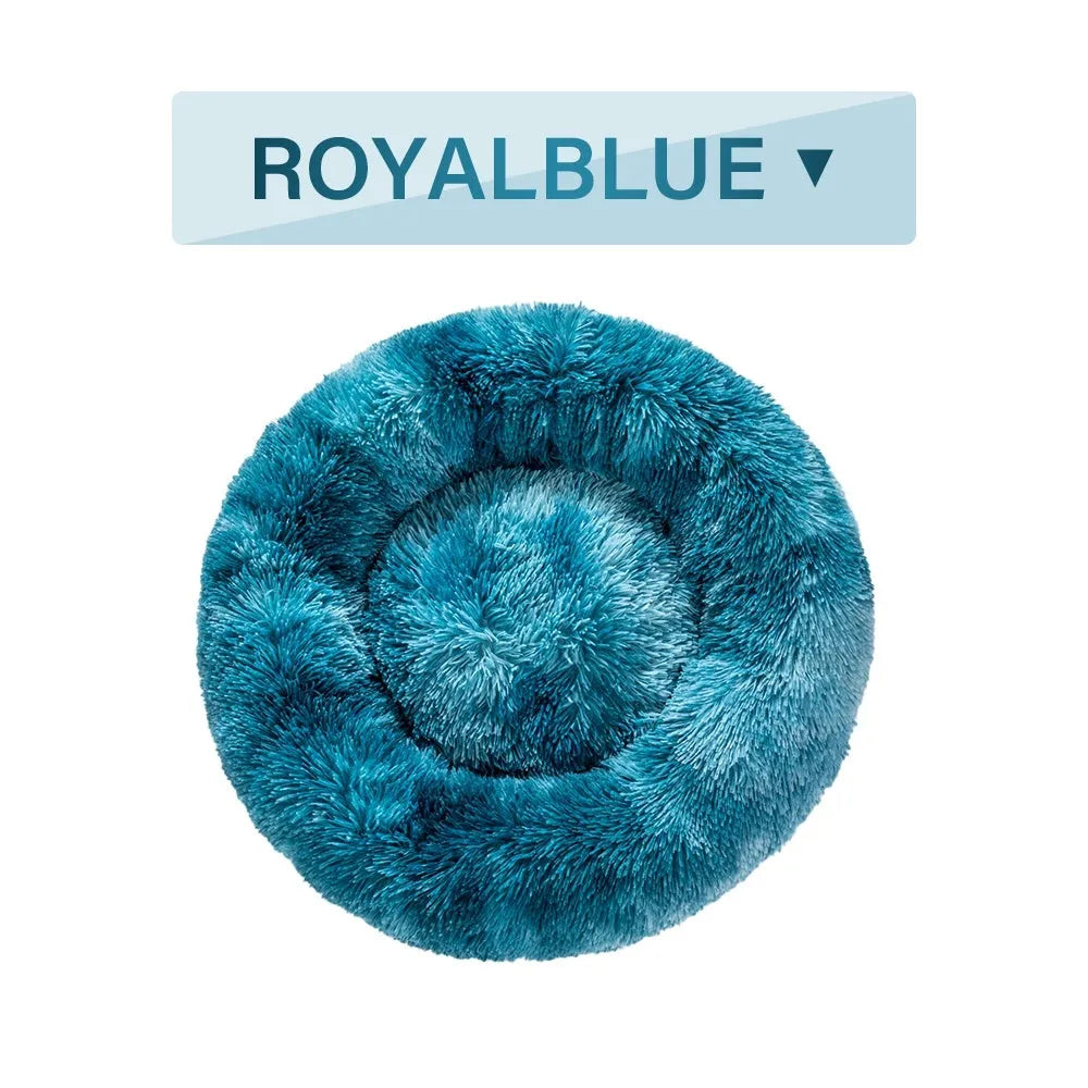 Fluffy donut-shaped dog bed in long plush material, shown in a grey colour, with a raised rim.