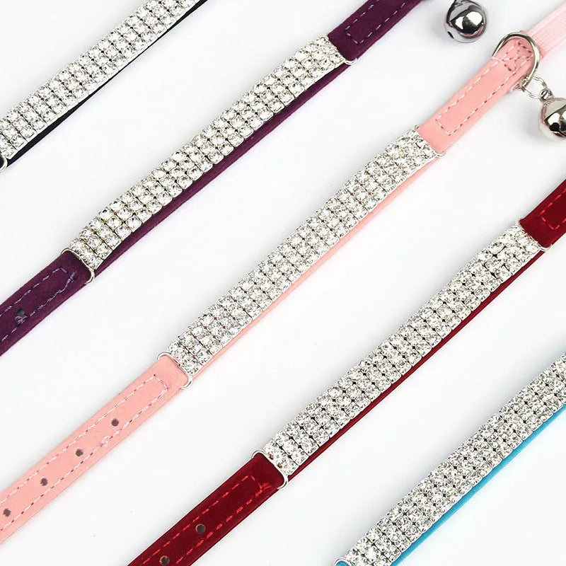 A red suede velvet cat collar with rhinestone decoration, showing the adjustable buckle.