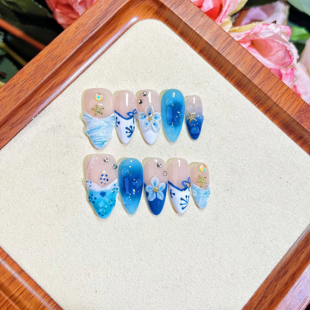 Blue summer ice transparent fake nails with hand-painted carved design, showing four size categories XS S M L