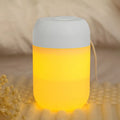 White cylindrical mini USB humidifier with aromatherapy function on a wooden surface.